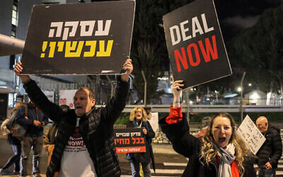 Des proches d'otages israéliens de Gaza rassemblés avec des sympathisants pour une manifestation demandant un accord immédiat pour faire libérer les captifs tout en bloquant une route à proximité du ministère de la Défense, à Tel Aviv, le 29 janvier 2024. (Crédit : Ahmad Gharabli/AFP)