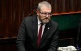 Le député d’extrême-droite Grzegorz Braun s’exprimant devant le Parlement polonais, à Varsovie, le 11 décembre 2023. (Crédit : Czarek Sokolowski/AP)