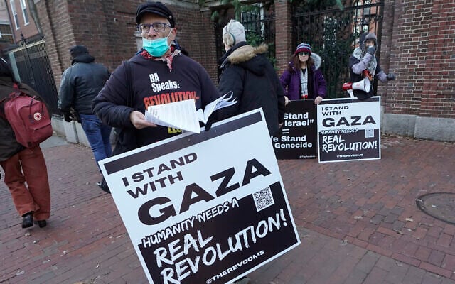 George Stevens de l’Université de Cambridge, dans le Massachusetts distribuant des tracts aux passants près d'une entrée de l'Université de Harvard, , tout en se joignant à des manifestants anti-Israël et pro-palestiniens, le 12 décembre 2023. (Crédit : Steven Senne/AP Photo)