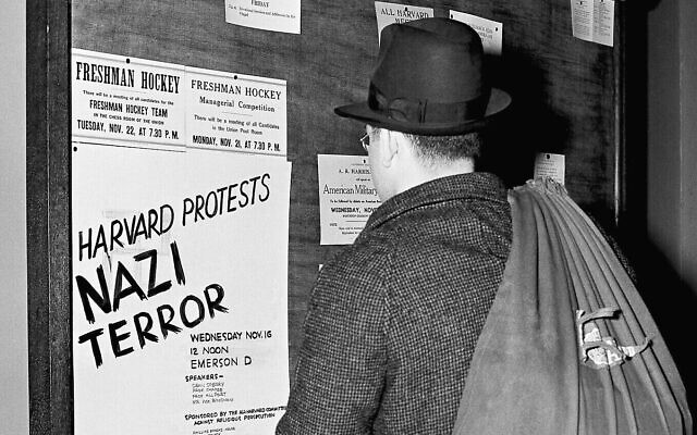 Un étudiant lisant un panneau d'affichage annonçant une réunion le 16 novembre 1938 à Harvard, à Cambridge, dans le Massachusetts, pour dénoncer la persécution des Juifs dans l'Allemagne nazie. (Crédit : Fox/AP)