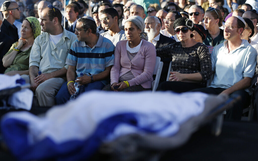Les parents de Naftali Fraenkel, 16 ans, Eyal Yifrah, 19 ans, et Gilad Shaer, 16 ans, de gauche à droite, les trois adolescents israéliens qui ont été enlevés et tués en Cisjordanie, pendant les funérailles communes de leurs fils, à Modiin, le 1er juillet 2014. (Crédit : Baz Ratner/AP/Pool) Les parents de Naftali Fraenkel, 16 ans, Eyal Yifrah, 19 ans, et Gilad Shaer, 16 ans, de gauche à droite, les trois adolescents israéliens qui ont été enlevés et tués en Cisjordanie, pendant les funérailles communes de leurs fils, à Modiin, le 1er juillet 2014. (Crédit : Baz Ratner/AP/Pool)