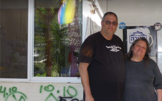 Shahar Schnorman et Ayelet Cohen, devant un mur de leur maison recouvert d'annotations des forces de secours, au kibboutz Kfar Aza, le 25 janvier 2024. (Crédit : Canaan Lidor/Times of Israel)