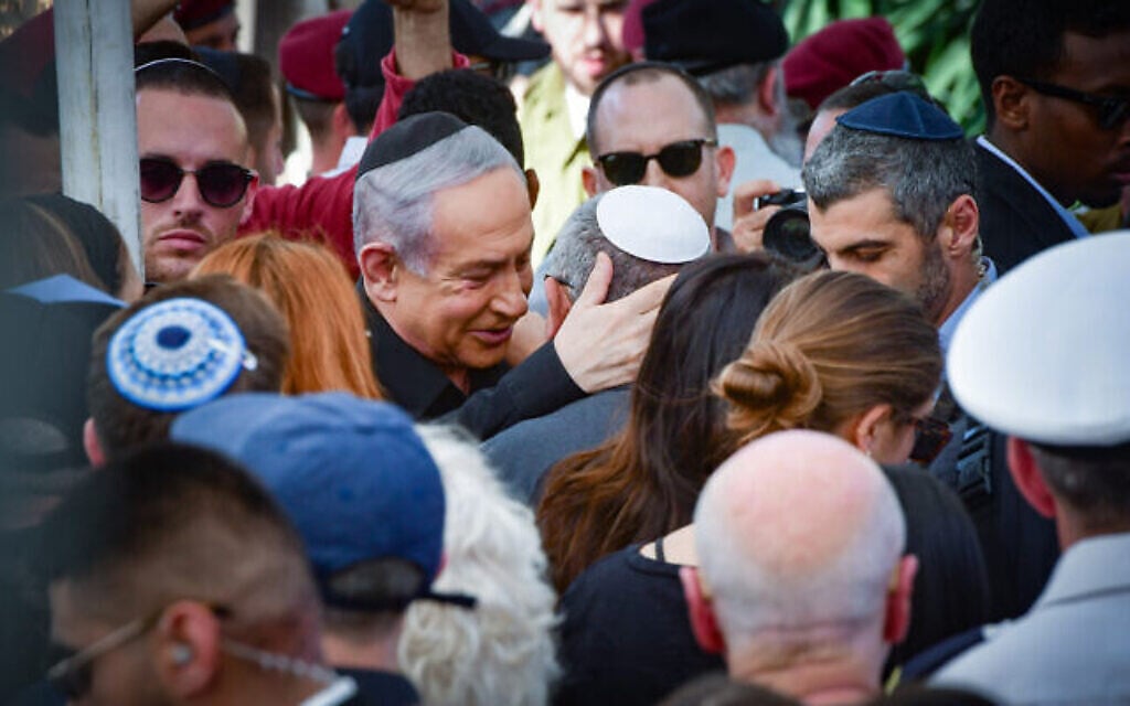 Le Premier ministre Benjamin Netanyahu (au centre à gauche) console le ministre du cabinet de guerre et ex-chef d'état-major de Le Premier ministre Benjamin Netanyahu (au centre à gauche) console Gadi Eisenkot (au centre, coiffé d’une kippa blanche), ancien ministre du cabinet de guerre et ancien chef d’état-major de Tsahal, lors des funérailles du fils de ce dernier, le sergent-chef (Rés.) Gal Meir Eisenkot, tué le 7 décembre lors d’une opération terrestre de Tsahal dans la bande de Gaza, à Herzliya, le 8 décembre 2023. (Crédit : Avshalom Sassoni/Flash90) Le Premier ministre Benjamin Netanyahu (au centre à gauche) console le ministre du cabinet de guerre et ex-chef d'état-major de Le Premier ministre Benjamin Netanyahu (au centre à gauche) console Gadi Eisenkot (au centre, coiffé d’une kippa blanche), ancien ministre du cabinet de guerre et ancien chef d’état-major de Tsahal, lors des funérailles du fils de ce dernier, le sergent-chef (Rés.) Gal Meir Eisenkot, tué le 7 décembre lors d’une opération terrestre de Tsahal dans la bande de Gaza, à Herzliya, le 8 décembre 2023. (Crédit : Avshalom Sassoni/Flash90)