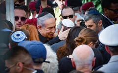 Le Premier ministre Benjamin Netanyahu (au centre à gauche) console le ministre du cabinet de guerre et ex-chef d'état-major de Le Premier ministre Benjamin Netanyahu (au centre à gauche) console Gadi Eisenkot (au centre, coiffé d’une kippa blanche), ancien ministre du cabinet de guerre et ancien chef d’état-major de Tsahal, lors des funérailles du fils de ce dernier, le sergent-chef (Rés.) Gal Meir Eisenkot, tué le 7 décembre lors d’une opération terrestre de Tsahal dans la bande de Gaza, à Herzliya, le 8 décembre 2023. (Crédit : Avshalom Sassoni/Flash90)