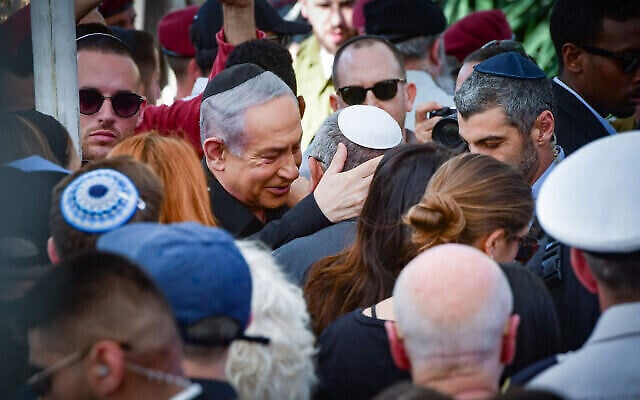 Le Premier ministre Benjamin Netanyahu (au centre à gauche) console le ministre du cabinet de guerre et ex-chef d'état-major de Le Premier ministre Benjamin Netanyahu (au centre à gauche) console Gadi Eisenkot (au centre, coiffé d’une kippa blanche), ancien ministre du cabinet de guerre et ancien chef d’état-major de Tsahal, lors des funérailles du fils de ce dernier, le sergent-chef (Rés.) Gal Meir Eisenkot, tué le 7 décembre lors d’une opération terrestre de Tsahal dans la bande de Gaza, à Herzliya, le 8 décembre 2023. (Crédit : Avshalom Sassoni/Flash90)