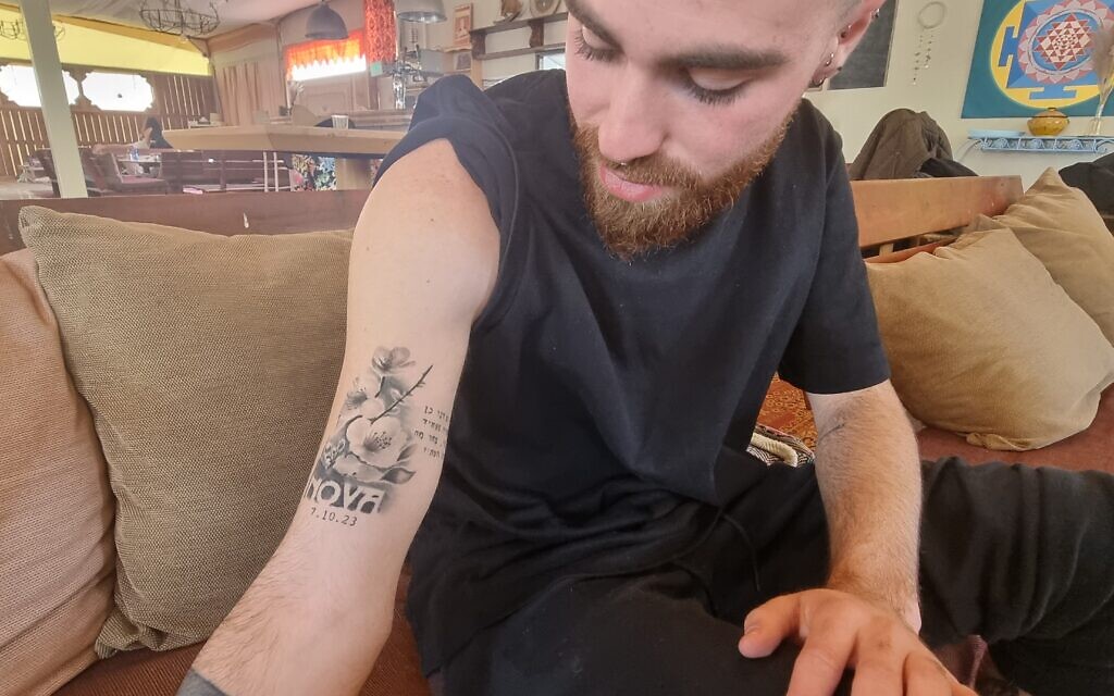 Niv, 24 ans, rescapé de Supernova arborant un tatouage avec inscrit Nova et la date 7.10.2023. (Crédit : Alexandra Vardi)