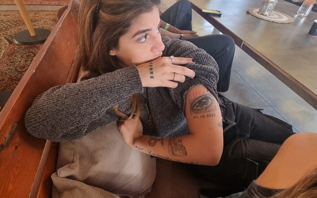 Shira Bitacho, 21 ans, rescapée du Festival Supernova le 7 octobre 2023, arborant un tatouage d'un oeil rempli de larmes au dessus de l'inscription 07.10.2023. (Crédit : Alexandra Vardi)