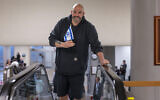 Le sénateur John Fetterman, D-Pa, tient un petit drapeau israélien alors qu'il se dirige vers la chambre pour un vote, au Capitole à Washington, le 25 janvier 2024. (Crédit : J. Scott Applewhite/AP)