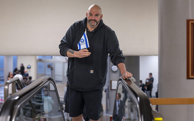 Le sénateur John Fetterman, D-Pa, tient un petit drapeau israélien alors qu'il se dirige vers la chambre pour un vote, au Capitole à Washington, le 25 janvier 2024. (Crédit : J. Scott Applewhite/AP) Le sénateur John Fetterman, D-Pa, tient un petit drapeau israélien alors qu'il se dirige vers la chambre pour un vote, au Capitole à Washington, le 25 janvier 2024. (Crédit : J. Scott Applewhite/AP)
