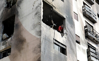 Un homme vérifie les dégâts dans un appartement d'un immeuble résidentiel qui aurait été visé par des frappes aériennes israéliennes dans le quartier de Kafr Sousa de la capitale syrienne Damas, le 21 février 2024. (Crédit : LOUAI BESHARA / AFP)