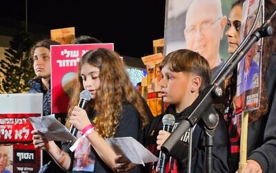 Hili Cooper et Or Nohomovitc parlant aux manifestants de leur grand-père, Amiram Cooper, qui est retenu en otage à Gaza, lors d'un rassemblement pour la libération des Israéliens kidnappés par les terroristes du Hamas sur la "Place des Otages", à Tel Aviv, le 10 février 2024. (Crédit : Forum des familles des otages et disparus)