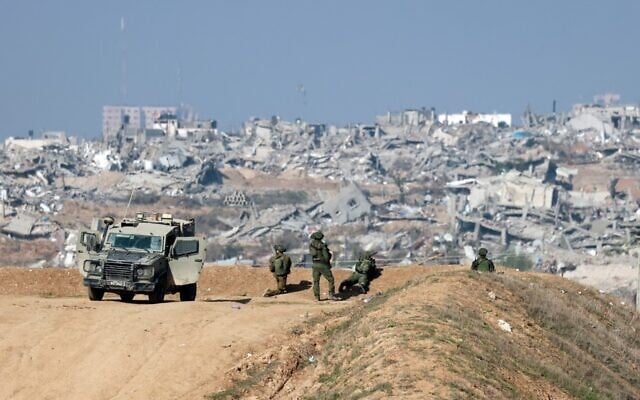Des soldats israéliens observant Gaza City depuis la frontière israélienne avec le nord de la bande de Gaza, sur une photo prise à la frontière israélienne avec le nord de la bande de Gaza le 1er janvier 2024. (Crédit : Menahem Kahana/AFP) Des soldats israéliens observant Gaza City depuis la frontière israélienne avec le nord de la bande de Gaza, sur une photo prise à la frontière israélienne avec le nord de la bande de Gaza le 1er janvier 2024. (Crédit : Menahem Kahana/AFP)