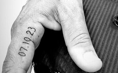 Un tatouage "07.10.23" sur la main droite d'un évacué du kibboutz Erez. (Crédit : Lior Yosefi)