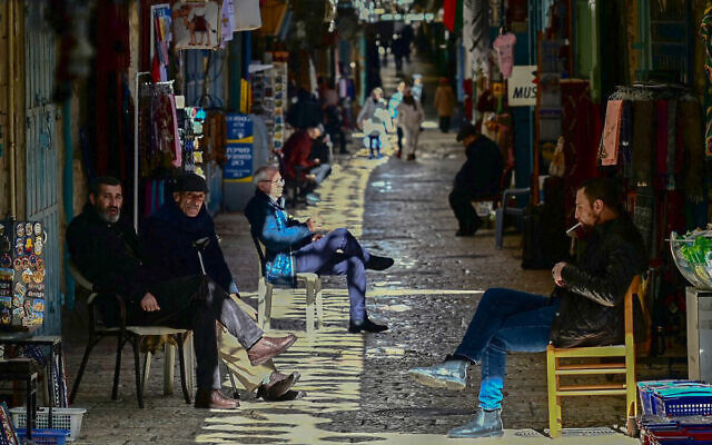 Des commerçants assis devant leurs magasins, dans la Vieille Ville de Jérusalem, le 13 janvier 2024. (Crédit : Alberto Pizzoli/AFP) Des commerçants assis devant leurs magasins, dans la Vieille Ville de Jérusalem, le 13 janvier 2024. (Crédit : Alberto Pizzoli/AFP)