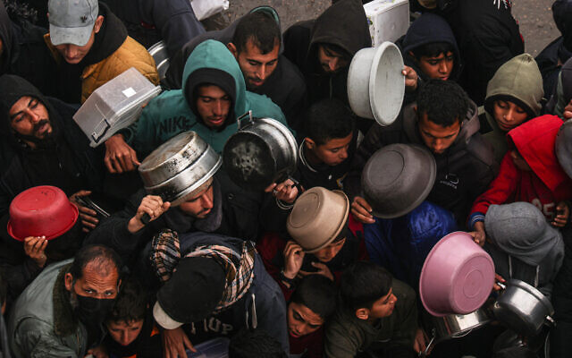 Des Palestiniens reçoivent des rations alimentaires dans un camp pour déplacés, à Rafah, dans le sud de Gaza, le 2 février 2024. (Crédit : Said Khatib / AFP)
