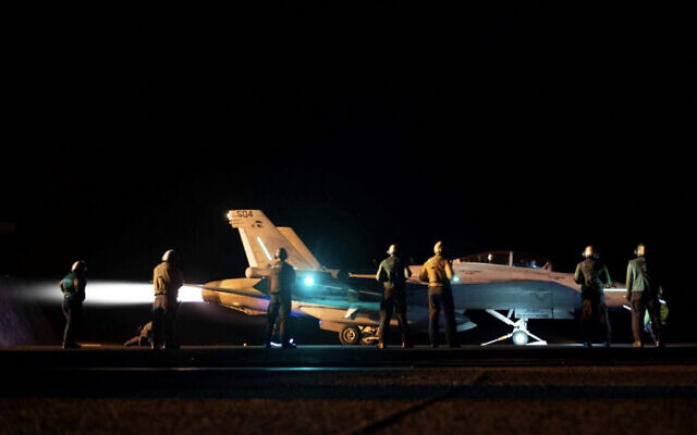 Sur cette photo diffusée par le Commandement central américain, le 3 février 2024, les forces du Commandement central sont à côté d'un avion de chasse sur le porte-avion USS Dwight D. Eisenhower alors que des frappes sont en cours contre des cibles Houthis au Yémen. (Crédit : US Central Command/AFP) Sur cette photo diffusée par le Commandement central américain, le 3 février 2024, les forces du Commandement central sont à côté d'un avion de chasse sur le porte-avion USS Dwight D. Eisenhower alors que des frappes sont en cours contre des cibles Houthis au Yémen. (Crédit : US Central Command/AFP)
