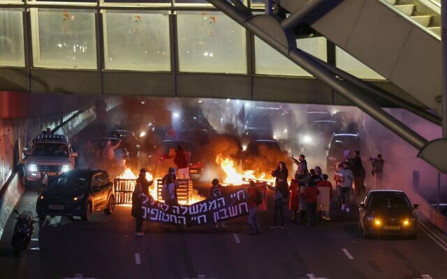 Les familles des otages détenus par les terroristes du Hamas à Gaza et leurs soutiens bloquent l'autoroute Ayalon pendant une manifestation appelant à leur libération à Tel Aviv, le 10 février 2024. (Crédit : Flash90)