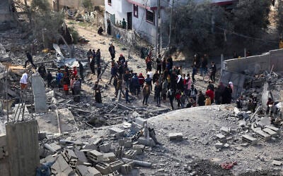 Des Palestiniens inspectant les dégâts causés à l’immeuble où deux otages israéliens étaient détenus avant d'être secourus lors d'une opération des forces de sécurité israéliennes à Rafah, dans le sud de la bande de Gaza, le 12 février 2024. (Crédit : Saïd Khatib/AFP)