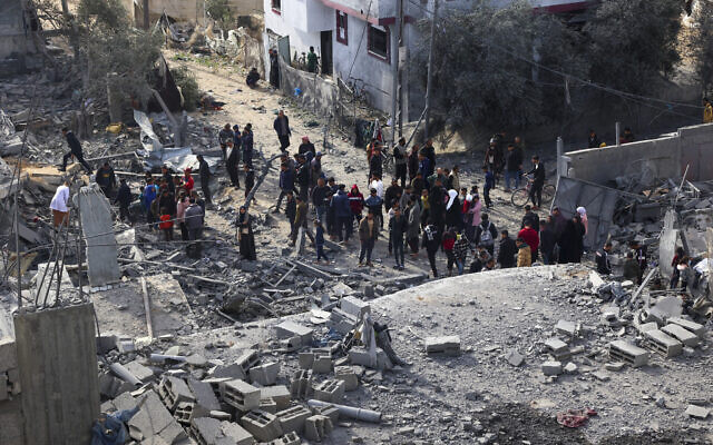 Des Palestiniens inspectant les dégâts causés à l’immeuble où deux otages israéliens étaient détenus avant d'être secourus lors d'une opération des forces de sécurité israéliennes à Rafah, dans le sud de la bande de Gaza, le 12 février 2024. (Crédit : Saïd Khatib/AFP) Des Palestiniens inspectant les dégâts causés à l’immeuble où deux otages israéliens étaient détenus avant d'être secourus lors d'une opération des forces de sécurité israéliennes à Rafah, dans le sud de la bande de Gaza, le 12 février 2024. (Crédit : Saïd Khatib/AFP)