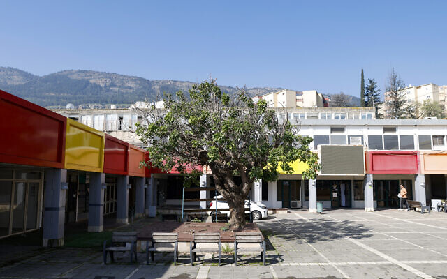Un homme marche devant des magasins fermés dans la ville de Kiryat Shmona, au nord d'Israël, près de la frontière avec le Liban, le 22 février 2024.  (Crédit : Jalaa MAREY / AFP)