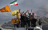 Des partisans du Hezbollah agitent des drapeaux iraniens lors d'une manifestation à la frontière libano-israélienne, près du village de Kafr Kila, dans le sud du Liban, le 14 mai 2021. (Crédit : AP Photo/Mohammed Zaatari)