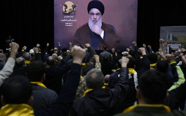 Les partisans du Hezbollah, soutenu par l'Iran, lèvent le poing et acclament le chef du groupe terroriste, Sayyed Hassan Nasrallah, intervenant par visioconférence, pendant un rassemblement marquant "la Journée des résistants blessés" dans le sud de Beyrouth, au Liban, le 13 février 2024. (Crédit : AP Photo/Hussein Malla) Les partisans du Hezbollah, soutenu par l'Iran, lèvent le poing et acclament le chef du groupe terroriste, Sayyed Hassan Nasrallah, intervenant par visioconférence, pendant un rassemblement marquant "la Journée des résistants blessés" dans le sud de Beyrouth, au Liban, le 13 février 2024. (Crédit : AP Photo/Hussein Malla)