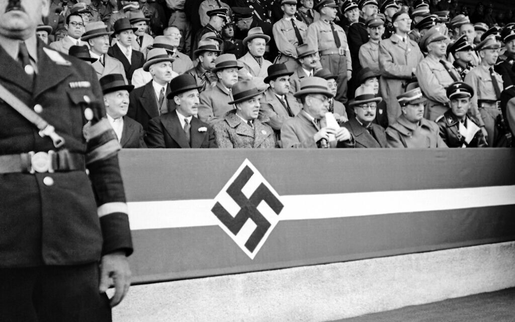 Adolf Hitler prononçant un discours devant 48 000 garçons et 5 000 filles lors du congrès du parti nazi à Nuremberg, en Allemagne, le 11 septembre 1937, au cours d'un défilé auquel assistent des diplomates étrangers. De gauche à droite au premier rang : Antonio Marquis De Magaz, envoyé d'Espagne en Allemagne, Sir Neville Henderson, ambassadeur britannique, inconnu, Signor Attolico, ambassadeur italien, André François-Poncet, ambassadeur français, Vicco Von Buelow Schwante, chef du protocole au ministère allemand des Affaires étrangères. (Crédit : AP/Archives) Adolf Hitler prononçant un discours devant 48 000 garçons et 5 000 filles lors du congrès du parti nazi à Nuremberg, en Allemagne, le 11 septembre 1937, au cours d'un défilé auquel assistent des diplomates étrangers. De gauche à droite au premier rang : Antonio Marquis De Magaz, envoyé d'Espagne en Allemagne, Sir Neville Henderson, ambassadeur britannique, inconnu, Signor Attolico, ambassadeur italien, André François-Poncet, ambassadeur français, Vicco Von Buelow Schwante, chef du protocole au ministère allemand des Affaires étrangères. (Crédit : AP/Archives)