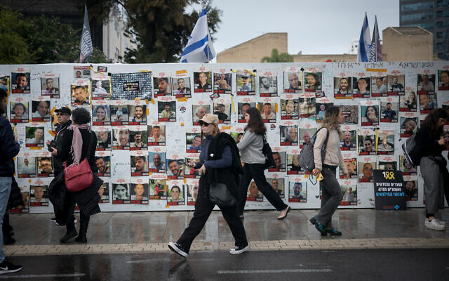 Des personnes passant devant les affiches des otages toujours détenus à Gaza lors d'un rassemblement de 24 heures marquant le 100e jour depuis le 7 octobre, "Place des Otages", à Tel Aviv, le 14 janvier 2024. (Crédit : Miriam Alster/FLASH90) Des personnes passant devant les affiches des otages toujours détenus à Gaza lors d'un rassemblement de 24 heures marquant le 100e jour depuis le 7 octobre, "Place des Otages", à Tel Aviv, le 14 janvier 2024. (Crédit : Miriam Alster/FLASH90)