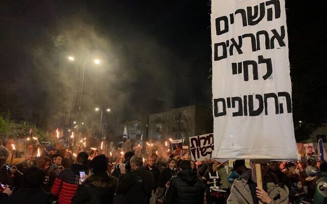 Des manifestants sur la place de Paris à Jérusalem, le 24 février 2024, à côté d'une banderole sur laquelle on peut lire : « Les ministres sont responsables de la vie des otages. » (Crédit : Charlie Summers/Times of Israël) Des manifestants sur la place de Paris à Jérusalem, le 24 février 2024, à côté d'une banderole sur laquelle on peut lire : « Les ministres sont responsables de la vie des otages. » (Crédit : Charlie Summers/Times of Israël)