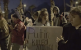 Un manifestant tenant une pancarte sur laquelle on peut lire "Poutine a tué Navalny" lors d'une veillée organisée par des expatriés russes à la mémoire d'Alexei Navalny, critique du Kremlin, devant l'ambassade de Russie, à Tel Aviv, le 16 février 2024. (Crédit : Capture d'écran : X/Kan  ; utilisée conformément à l'article 27a de la loi sur le droit d'auteur)