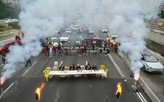 Des familles d'otages ont installé une table pour le dîner de Shabbat et appelé à un accord immédiat pour libérer leurs proches de captivité, bloquant l'autoroute Ayalon à Tel Aviv, le 23 février 2024, sur une photo fournie par des militants. (Crédit : Amir Terkel)