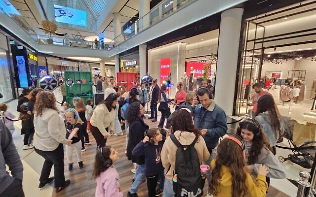 Des familles israéliennes profitant d'une fête avec casques de musique au centre commercial TLV, à Tel Aviv lors de la journée des élections municipales le 27 février 2024. (Crédit : Autorisation) Des familles israéliennes profitant d'une fête avec casques de musique au centre commercial TLV, à Tel Aviv lors de la journée des élections municipales le 27 février 2024. (Crédit : Autorisation)