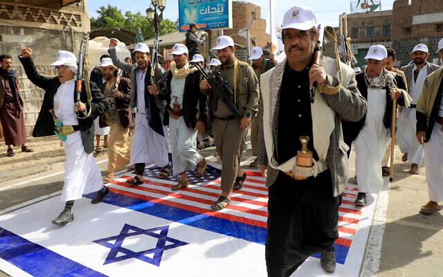 Des membres des Houthis soutenus par l'Iran au Yémen marchant sur des drapeaux israéliens et américains peints dans la rue à Sanaa lors d'un rassemblement de soutien aux Palestiniens dans le cadre de la guerre entre Israël et le groupe terroriste Hamas à Gaza, le 28 février 2024. (Crédit : Mohammed Huwais/AFP) Des membres des Houthis soutenus par l'Iran au Yémen marchant sur des drapeaux israéliens et américains peints dans la rue à Sanaa lors d'un rassemblement de soutien aux Palestiniens dans le cadre de la guerre entre Israël et le groupe terroriste Hamas à Gaza, le 28 février 2024. (Crédit : Mohammed Huwais/AFP)