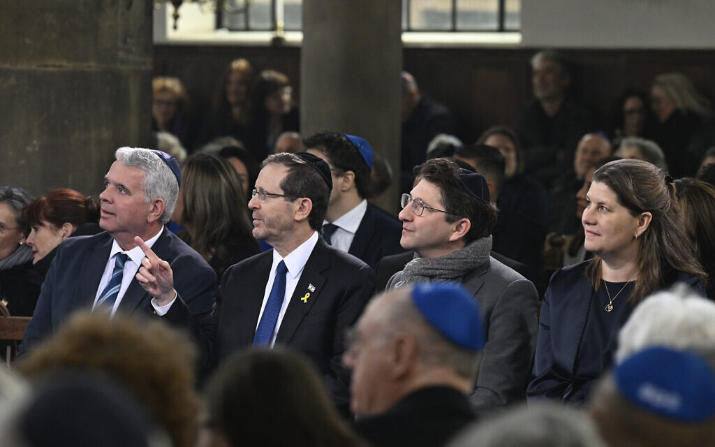 Le président d'Israël Isaac Herzog, deuxième à gauche, pointe du doigt la synagogue portugaise lors d'une cérémonie marquant l'ouverture du nouveau musée national de la Shoah à Amsterdam, aux Pays-Bas, le 10 mars 2024. (Crédit : Patrick van Emst/AP)