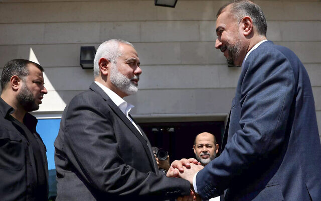 Cette photo polycopiée fournie par le ministère iranien des Affaires étrangères le 13 février 2024 montre le ministre des Affaires étrangères iranien Hossein Amir Abdollahian (R) rencontrant le chef du bureau politique du Hamas, Ismail Haniyeh, à Doha. (Crédit : ministère des Affaires étrangères iranien / AFP)