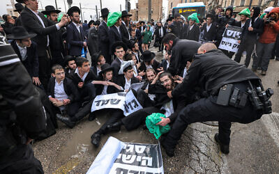 Des policiers israéliens tentant de déloger par la force des manifestants ultra-orthodoxes qui protestent contre leur enrôlement dans l'armée israélienne, à Jérusalem, le 18 mars 2024. (Crédit : Ahmad Gharabli/AFP)