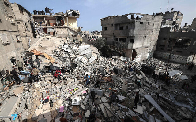 Des Palestiniens examinent les décombres de bâtiments détruits par des frappes israéliennes à Rafah, dans le sud de la bande de Gaza, le 27 mars 2024. (Crédit : MOHAMMED ABED / AFP) Des Palestiniens examinent les décombres de bâtiments détruits par des frappes israéliennes à Rafah, dans le sud de la bande de Gaza, le 27 mars 2024. (Crédit : MOHAMMED ABED / AFP)