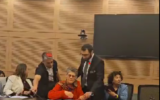 Michal Fruchtman de l’organisation Parents Against Child Detention est escortée hors d'une réunion de la commission Constitution, Droit et Justice de la Knesset suite à une dispute avec les législateurs, à Jérusalem, le 27 mars, 2024. (Crédit : Screenshot/X Video/Shai Glick)