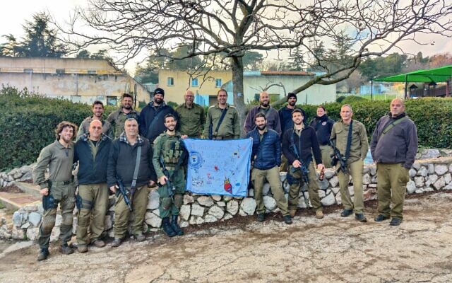 Illustration : Omri Sofer, au centre, avec une banderole de remerciement des enfants de l'équipe d'intervention d'urgence au kibboutz Misgav Am. Les enfants ont tous été évacués et seule l'équipe se trouve dans le kibboutz. (Crédit : Autorisation) Illustration : Omri Sofer, au centre, avec une banderole de remerciement des enfants de l'équipe d'intervention d'urgence au kibboutz Misgav Am. Les enfants ont tous été évacués et seule l'équipe se trouve dans le kibboutz. (Crédit : Autorisation)