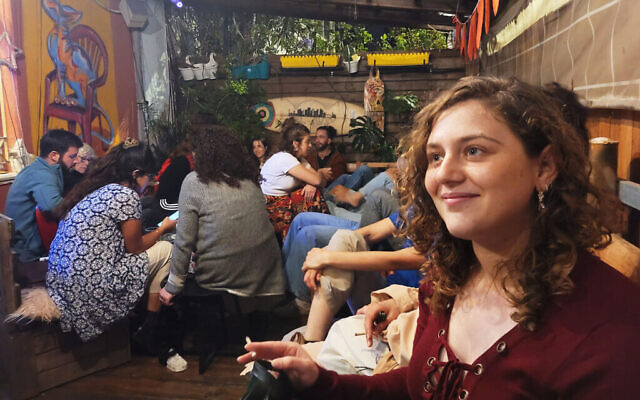 Ori Gini écoutant un ami parler lors d'un rassemblement pour les étudiants évacués du nord d'Israël, à Tel Aviv, le 26 mars 2024. (Crédit : Canaan Lidor/Times of Israel)