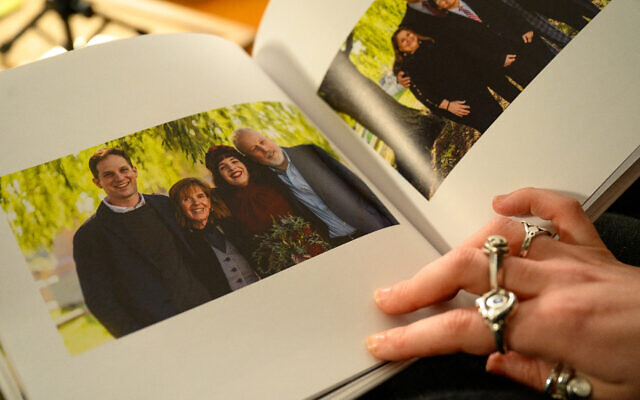 Danielle Gershkovich, sœur du journaliste détenu Evan Gershkovich, ouvre une photo de son frère et de ses parents dans son album de mariage, dans l'appartement de Danielle à Philadelphie, Pennsylvanie, le 27 février 2024. 
(Crédit : Kriston Jae Bethel / AFP)