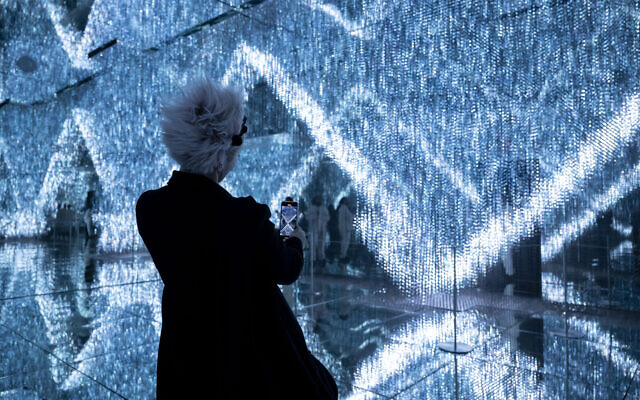 Un visiteur prend une photo d'une installation au Mercer Labs Museum of Art and Technology lors d'un vernissage, le 29 février 2024, à New York. (Crédit : ANGELA WEISS / AFP)