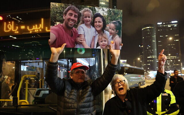 Les parents de Tamar Kedem Siman Tov, tuée avec son époux et leurs trois jeunes enfants à Nir Oz le 7 octobre, brandissant une photo d'eux lors d'une manifestation, à Tel Aviv, le 2 mars 2024. (Crédit : Jack Guez/AFP) Les parents de Tamar Kedem Siman Tov, tuée avec son époux et leurs trois jeunes enfants à Nir Oz le 7 octobre, brandissant une photo d'eux lors d'une manifestation, à Tel Aviv, le 2 mars 2024. (Crédit : Jack Guez/AFP)