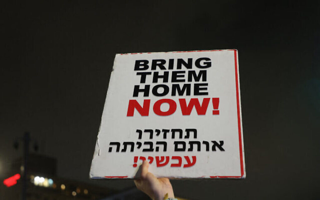 Un manifestant tient une pancarte appelant à une action pour obtenir la libération des otages israéliens détenus à Gaza lors d'une manifestation près de la résidence officielle du premier ministre à Jérusalem, le 2 mars 2024. (Crédit : GIL COHEN-MAGEN / AFP)