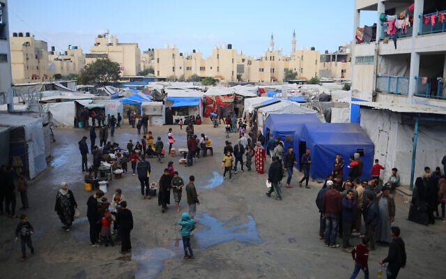 Des Palestiniens déplacés se promenant dans une école de l'UNRWA abritant des Palestiniens déplacés, à Rafah, dans le sud de la bande de Gaza, le 4 mars 2024. (Crédit : AFP)