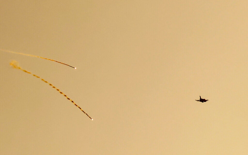 Un avion de chasse de l'armée de l'air israélienne tirant des fusées éclairantes alors qu'il survole la zone frontalière avec le sud du Liban, sur une photo prise depuis une position dans le nord d'Israël, le 4 mars 2024. (Crédit : Jalaa Marey/AFP)