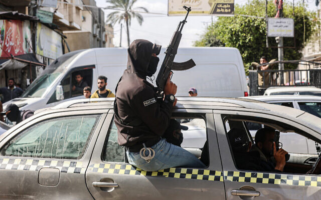 Des membres masqués et armés des "Comités populaires de protection", créés par le Hamas et d'autres groupes terroristes patrouillant dans les rues de la ville de Rafah, au sud de Gaza, le 6 mars 2024. (Crédit : Saïd Khatib/AFP) Des membres masqués et armés des "Comités populaires de protection", créés par le Hamas et d'autres groupes terroristes patrouillant dans les rues de la ville de Rafah, au sud de Gaza, le 6 mars 2024. (Crédit : Saïd Khatib/AFP)