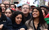 Jean-Luc Mélenchon (au centre), leader de La France Insoumise (LFI), Rima Hassan (à droite), fondatrice franco-palestinienne de l'Observatoire des camps de réfugiés (OCR) et tête de liste de LFI pour les élections européennes, et Manon Aubry (à gauche) brandissent une banderole lors d'une manifestation appelant à un cessez-le-feu à Gaza, place de la République, à Paris, le 9 mars 2024. (Crédit : Emmanuel Dunand/AFP)