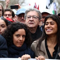 Jean-Luc Mélenchon (au centre), leader de La France Insoumise (LFI), Rima Hassan (à droite), fondatrice franco-palestinienne de l'Observatoire des camps de réfugiés (OCR) et tête de liste de LFI pour les élections européennes, et Manon Aubry (à gauche) brandissent une banderole lors d'une manifestation appelant à un cessez-le-feu à Gaza, place de la République, à Paris, le 9 mars 2024. (Crédit : Emmanuel Dunand/AFP)