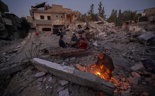 Des Palestiniens se préparant à rompre leur jeûne le premier jour du ramadan, au milieu des ruines de leur maison familiale à Deir el-Balah, dans le centre de la bande de Gaza, le 11 mars 2024. (Crédit : AFP) Des Palestiniens se préparant à rompre leur jeûne le premier jour du ramadan, au milieu des ruines de leur maison familiale à Deir el-Balah, dans le centre de la bande de Gaza, le 11 mars 2024. (Crédit : AFP)